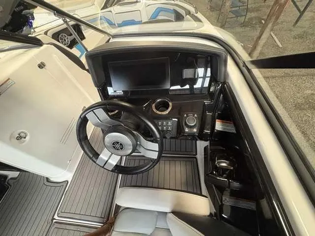 Slide: The Image of The image shows the cockpit of a 2018 Yamaha 242X boat with a modern helm. - 9