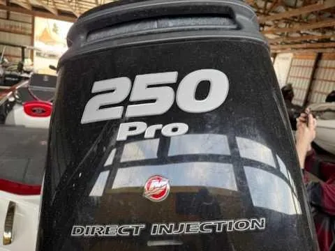 Slide: The Image of Close-up of an outboard motor labeled "250 Pro Direct Injection" in a storage facility. - 1