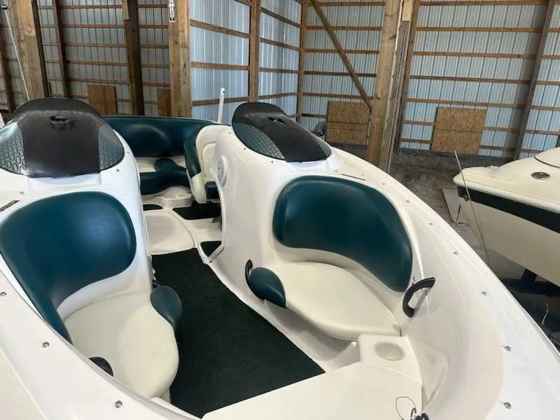 Slide: The Image of A 2003 Yamaha LS2000 boat with white and blue seats in a storage facility. - 1