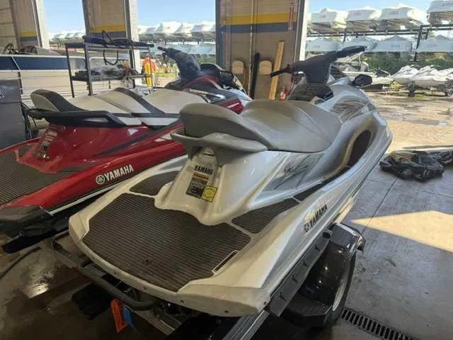 Slide: The Image of A 2012 Yamaha VX Cruiser jet ski is in a garage next to a red model. - 1