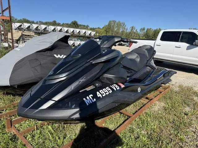 The Image of A black 2025 Yamaha WaveRunner FX Cruiser SVHO sits on a metal rack outdoors. - 0