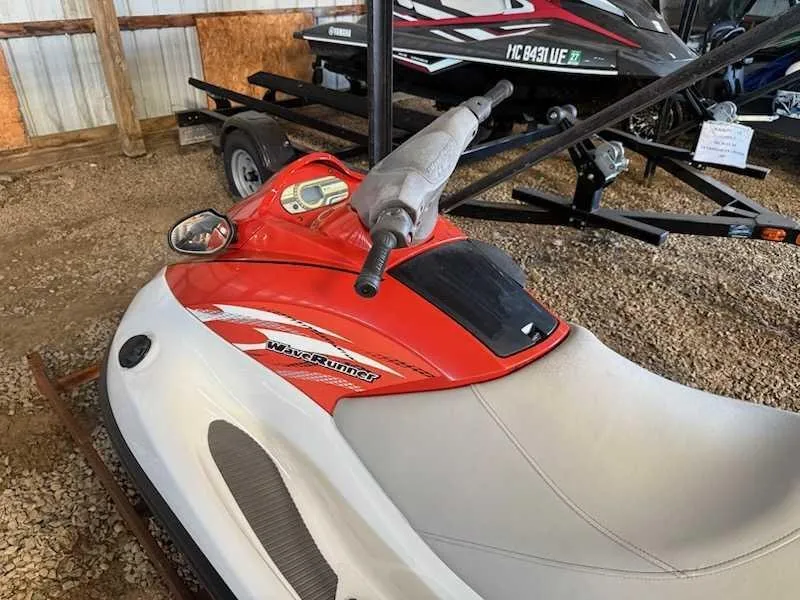 Slide: The Image of A red and white 2015 Yamaha V1 jet ski is on a trailer in a storage area. - 1