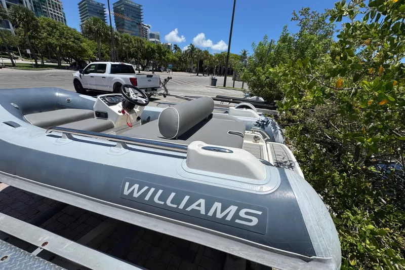 Slide: The Image of 2019 Williams Jet Tenders Sportjet 345 parked near trees and a white truck. - 10