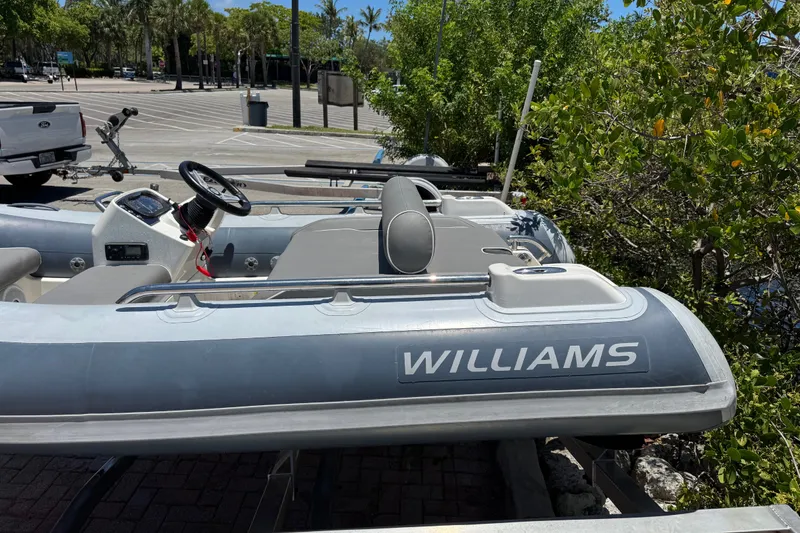 Slide: The Image of 2019 Williams Jet Tenders Sportjet 345 in a parking area, surrounded by greenery. - 12