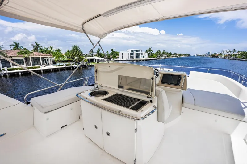 Slide: The Image of Luxurious 2013 Prestige 620 yacht deck with grill, seating, and scenic waterfront view. - 18