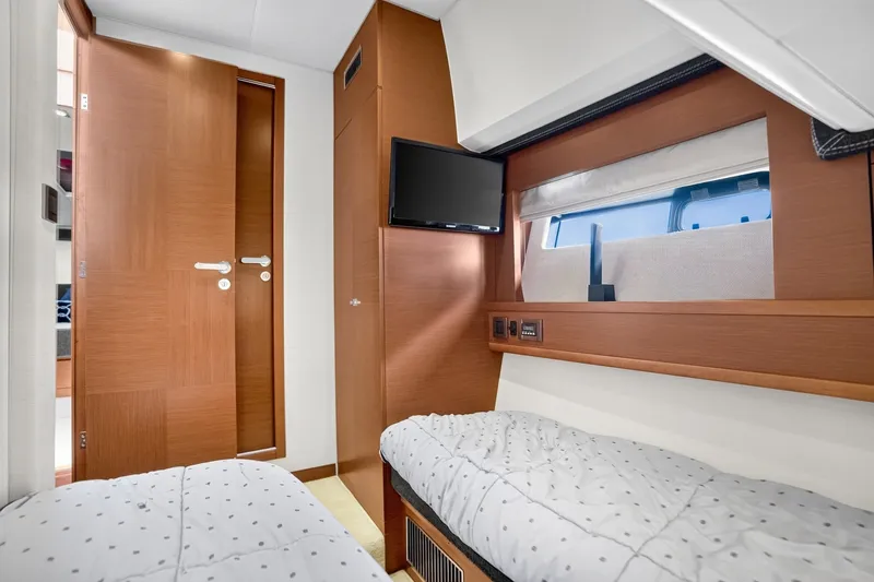Slide: The Image of Interior of 2013 Prestige 620 yacht cabin with twin beds and a wall-mounted TV. - 55