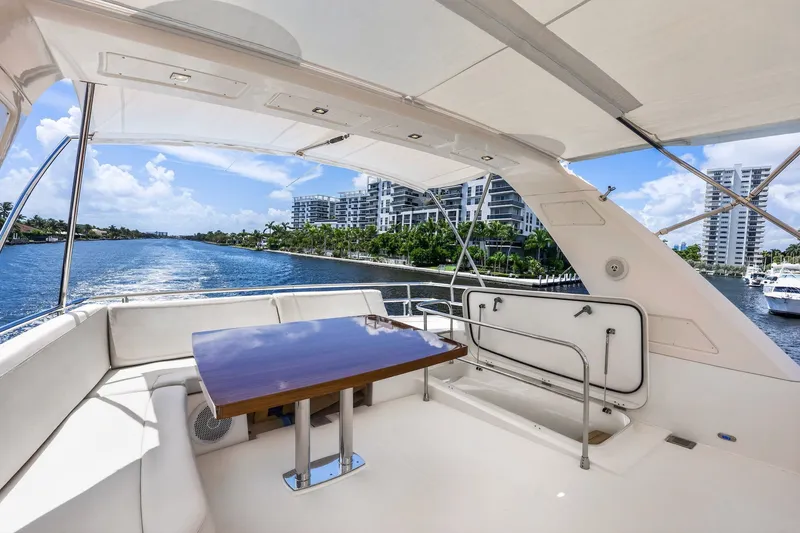 Slide: The Image of Luxurious 2013 Prestige 620 yacht deck with seating, table, and scenic waterfront view. - 17