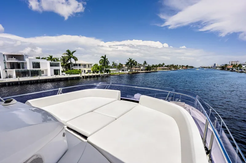 Slide: The Image of Prestige 620 yacht cruising along a scenic waterfront with luxury homes, 2013 model. - 21