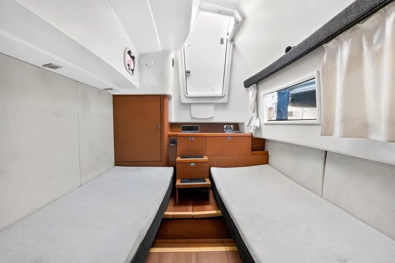Slide: The Image of Interior cabin of a 2013 Prestige 620 yacht with twin beds and wooden accents. - 58