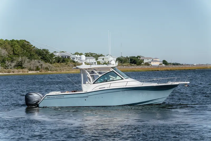 Slide: The Image of 2019 Grady-White Express 330 boat cruising on a calm waterway. - 5