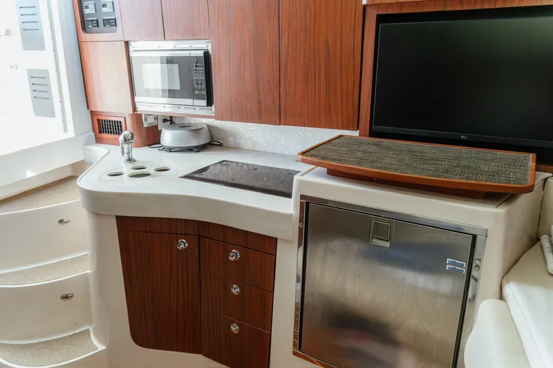 Slide: The Image of 2019 Grady-White Express 330 yacht interior with kitchenette, microwave, and TV. - 16