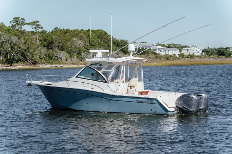 Slide: The Image of 2019 Grady-White Express 330 boat on calm water, surrounded by trees and houses. - 7
