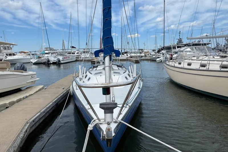 Slide: The Image of 1986 Catalina 38 sailboat docked in a marina, surrounded by other boats. - 2