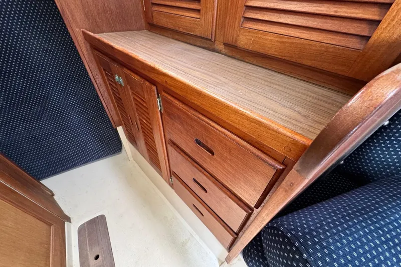 Slide: The Image of Wooden cabinetry inside 1986 Catalina 38 sailboat, featuring drawers and louvered doors. - 31