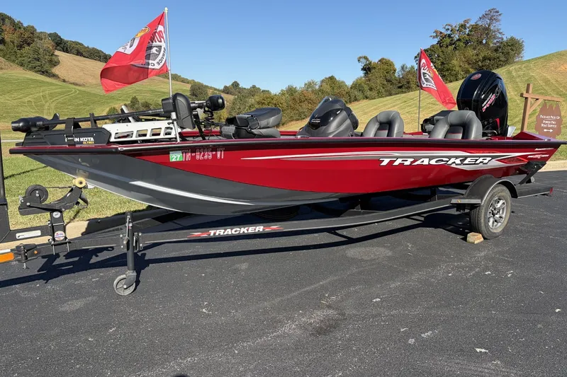 The Image of 2022 Tracker Pro Team 190 boat on trailer with flags, parked outdoors. - 0