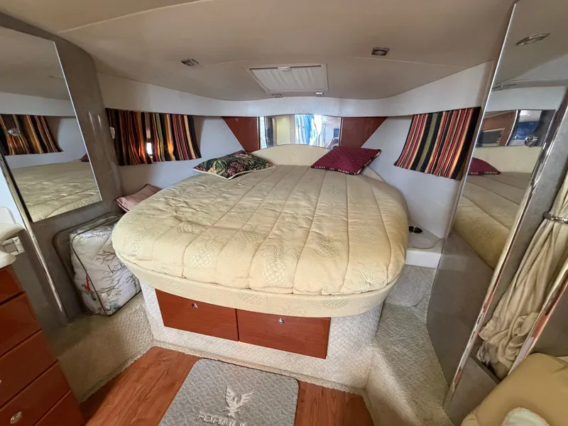 Slide: The Image of The cabin of a 2009 Formula 34 Performance Cruiser with a large, cozy bed and mirrors. - 11