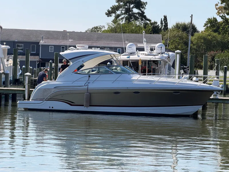 The Image of 2009 Formula 34 Performance Cruiser docked, sleek design, white with brown accents. - 0