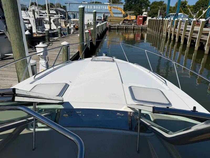 Slide: The Image of The boat is docked in a marina, surrounded by other boats and a crane in the background. - 16