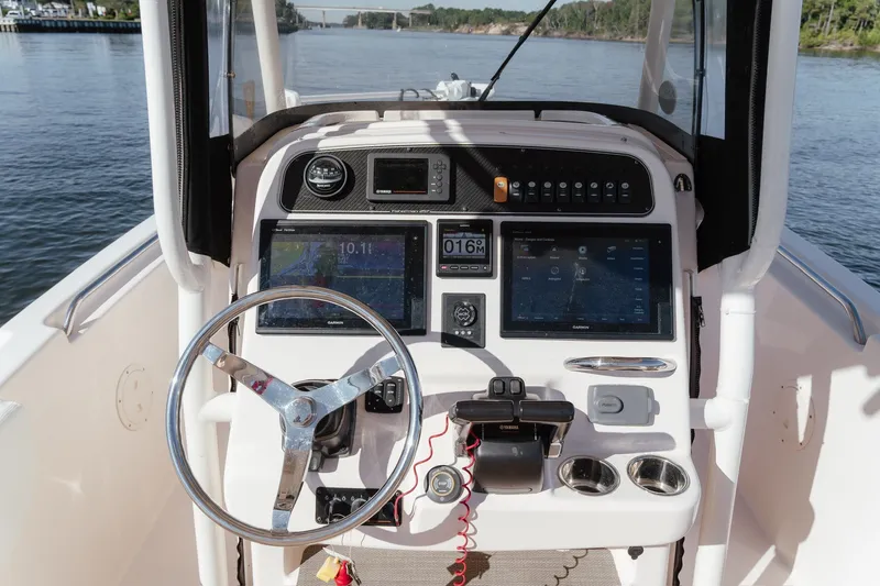 Slide: The Image of 2016 Grady-White Fisherman 257 boat dashboard with steering wheel and navigation controls. - 16