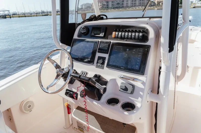 Slide: The Image of 2016 Grady-White Fisherman 257 boat console with steering wheel and navigation displays. - 14