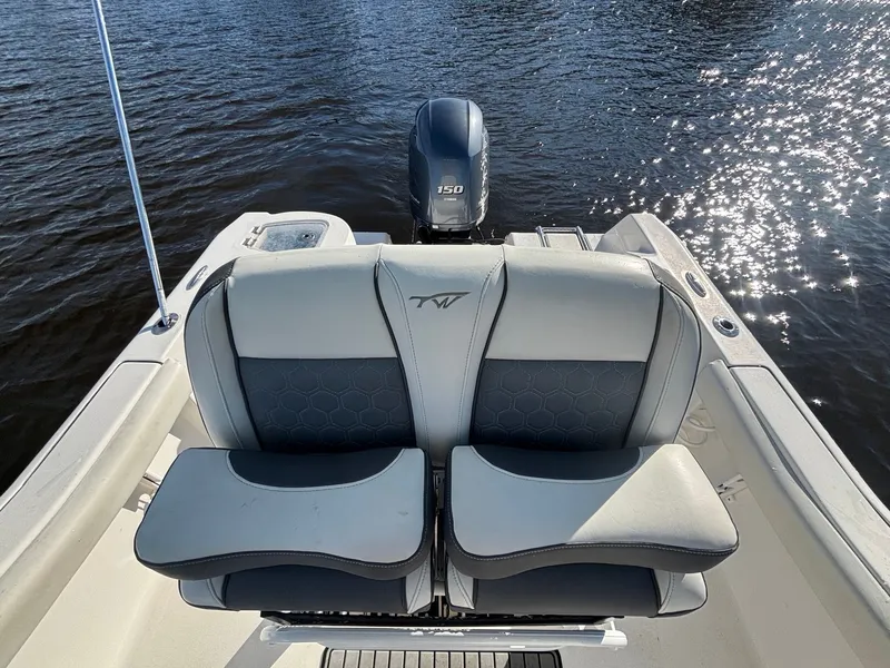 Slide: The Image of The image shows the stern of a 2020 Tidewater 210 CC Adventure boat on the water. - 13