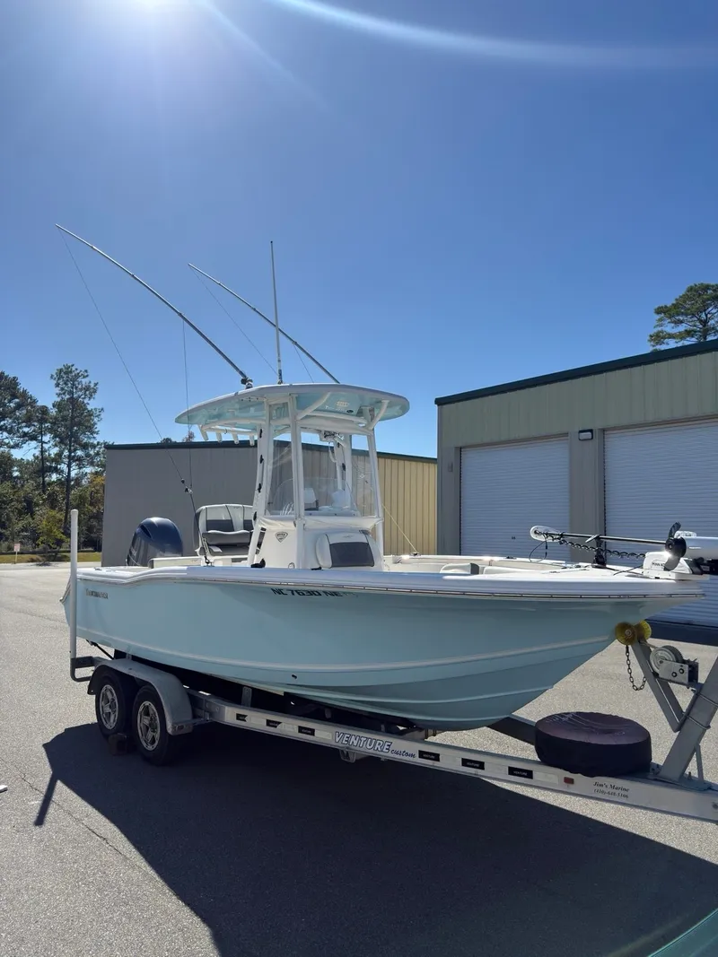 Slide: The Image of A 2020 Tidewater 210 CC Adventure boat on a trailer, parked in front of a building. - 16