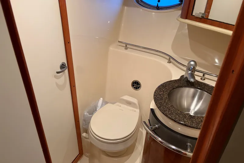 Slide: The Image of 2006 Sea Ray 40 Sundancer bathroom with toilet, sink, and porthole window. - 13