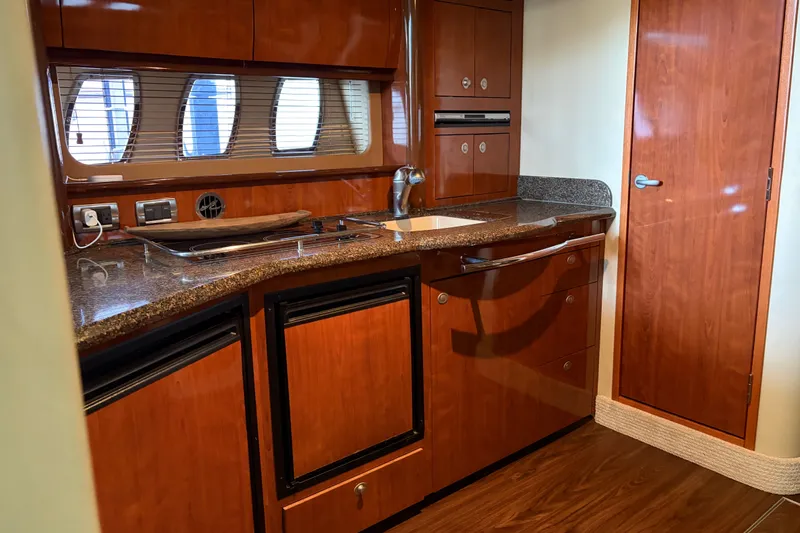 Slide: The Image of Luxurious 2006 Sea Ray 40 Sundancer yacht kitchen with wood cabinetry and modern appliances. - 10
