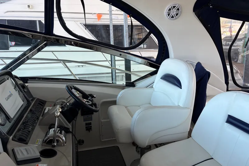 Slide: The Image of Interior cockpit of a 2006 Sea Ray 40 Sundancer yacht with white seating and navigation equipment. - 5