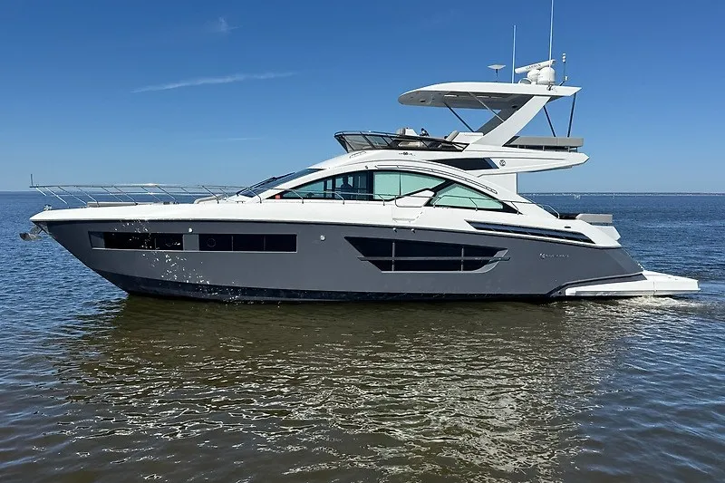 Slide: The Image of 2023 Cruisers Yachts 60 Fly luxury yacht on calm water under clear blue sky. - 3