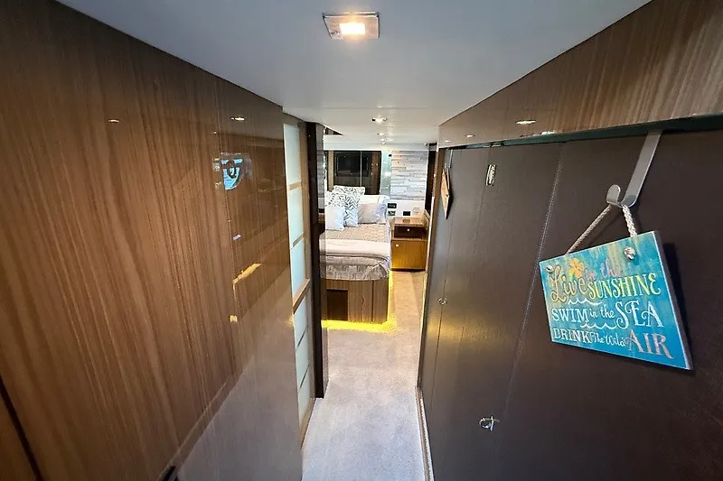 Slide: The Image of Luxurious interior of 2023 Cruisers Yachts 60 Fly, featuring elegant wood finishes and cozy bedroom. - 23
