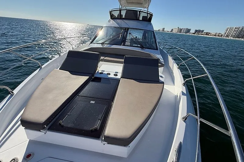 Slide: The Image of 2023 Cruisers Yachts 60 Fly on open water, featuring spacious sun loungers. - 35