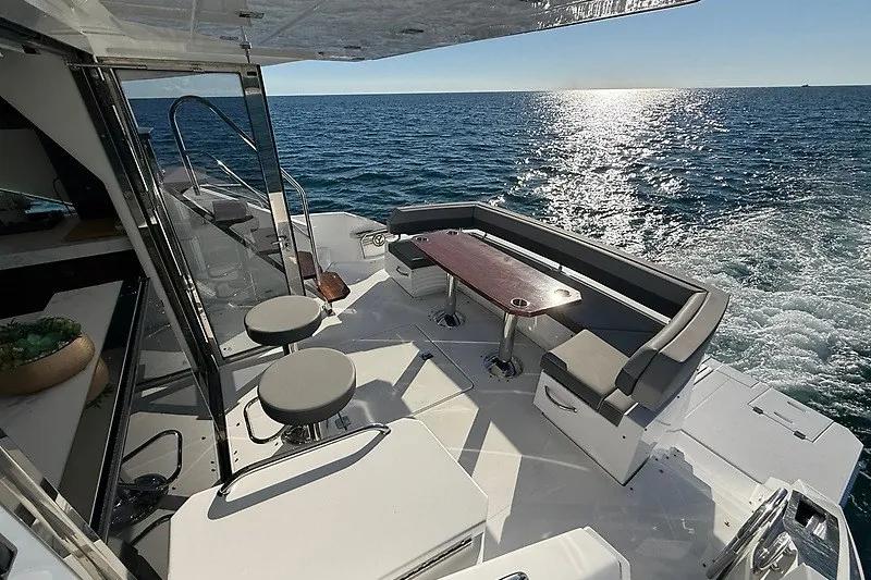 Slide: The Image of Luxurious 2023 Cruisers Yachts 60 Fly deck with seating, overlooking ocean waves. - 36