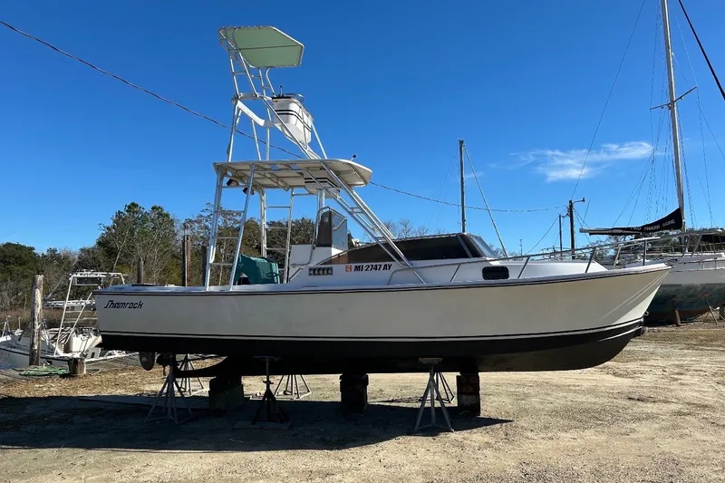 Slide: The Image of 1987 Shamrock 260 Stalker boat on stands, clear sky background. - 3