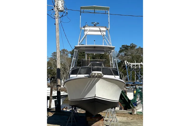 Slide: The Image of 1987 Shamrock 260 Stalker boat on dry dock, front view, clear sky background. - 4