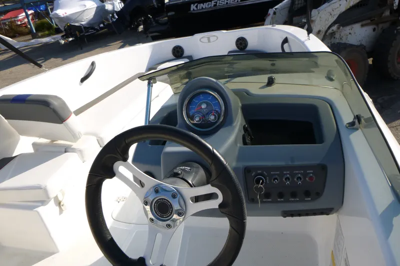 Slide: The Image of Interior view of a 2022 Tahoe T18 boat dashboard with steering wheel and controls. - 13