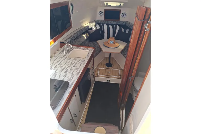 Slide: The Image of 1992 Luhrs Tournament 300 cabin interior with kitchenette, seating area, and nautical decor. - 18