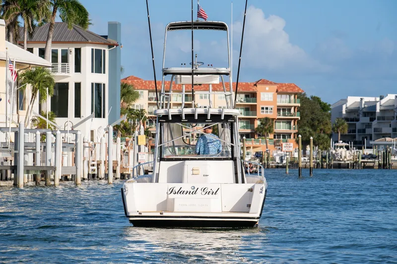 Slide: The Image of 1992 Luhrs Tournament 300 boat named "Island Girl" cruising near waterfront homes. - 9