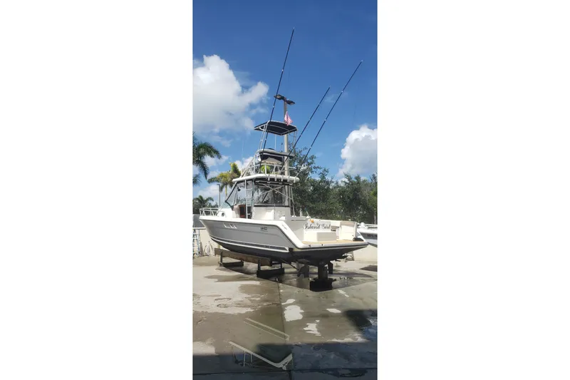 Slide: The Image of 1992 Luhrs Tournament 300 boat on dry dock with fishing rods and clear sky. - 14