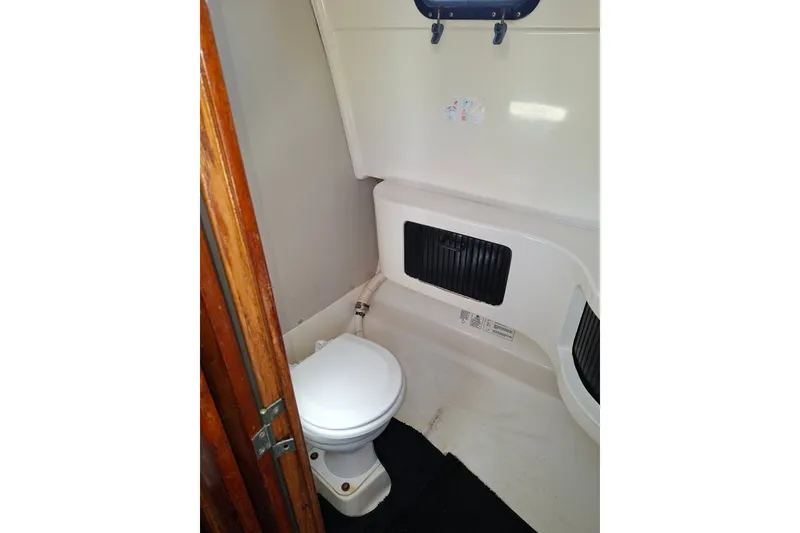 Slide: The Image of 1992 Luhrs Tournament 300 boat bathroom with toilet and storage compartments. - 29