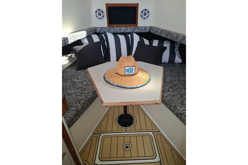 Slide: The Image of 1992 Luhrs Tournament 300 cabin interior with table, cushions, and straw hat. - 19