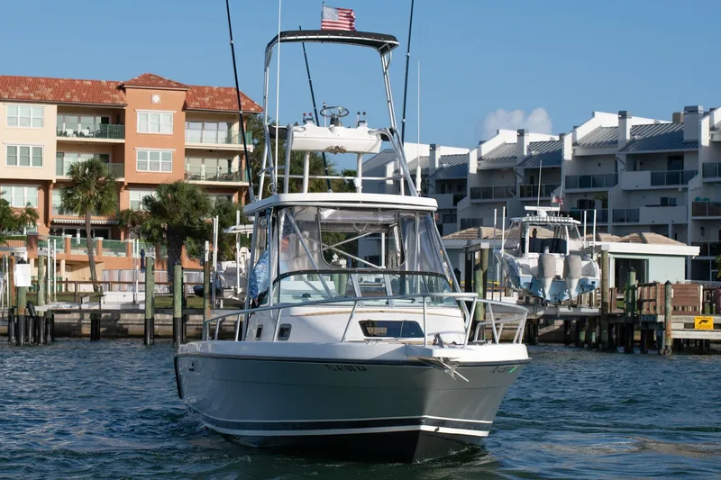 Slide: The Image of 1992 Luhrs Tournament 300 boat docked near waterfront buildings. - 3