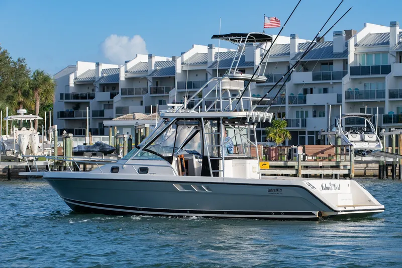 Slide: The Image of 1992 Luhrs Tournament 300 boat docked near modern waterfront buildings. - 8