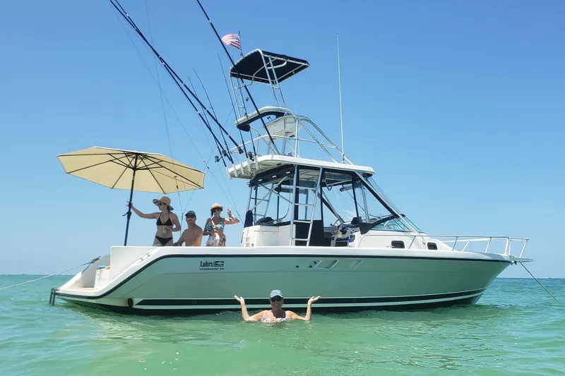 Slide: The Image of 1992 Luhrs Tournament 300 boat with people enjoying a sunny day on the water. - 12