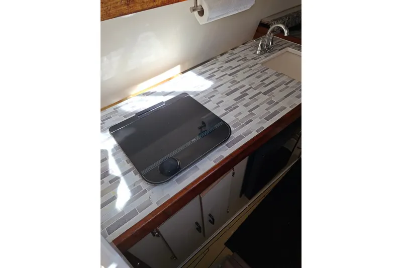Slide: The Image of 1992 Luhrs Tournament 300 boat kitchen with tiled countertop and sink. - 23