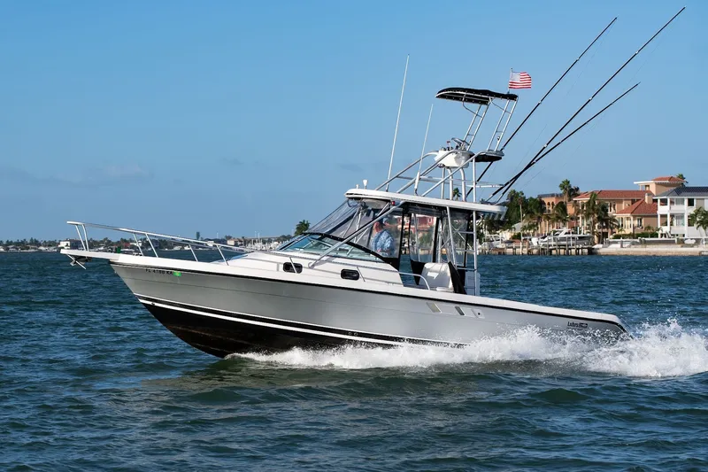 Slide: The Image of 1992 Luhrs Tournament 300 boat cruising on the water with fishing rods. - 10