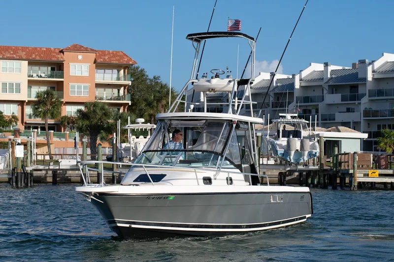 Slide: The Image of 1992 Luhrs Tournament 300 boat cruising near waterfront buildings. - 2