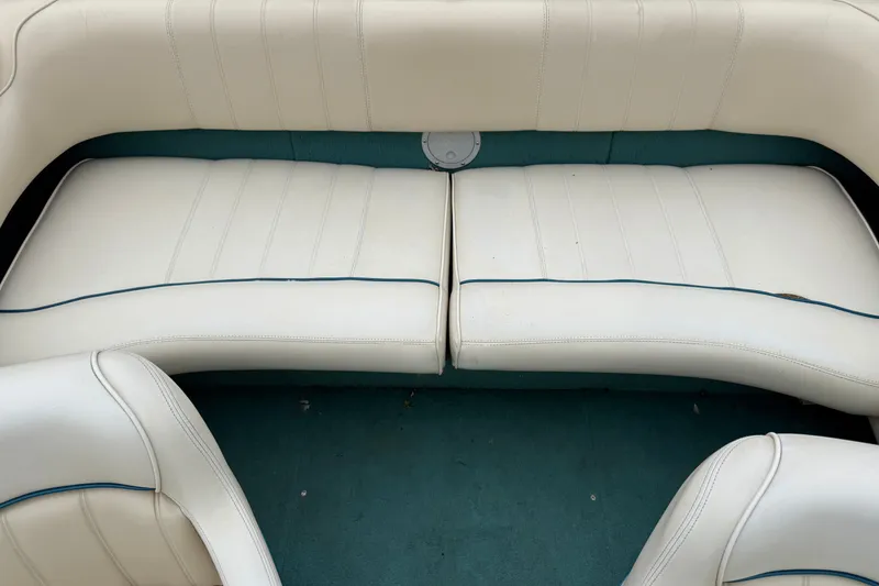 Slide: The Image of 1996 Sea Ray 190 Bow Rider interior with white cushioned seating and teal carpet. - 15