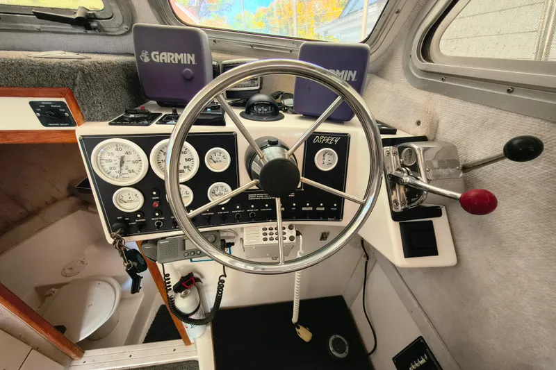 Slide: The Image of 2004 Osprey 26 Fisherman boat cockpit with steering wheel and Garmin navigation. - 13