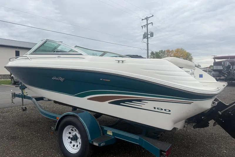 Slide: The Image of 1988 MasterCraft ProStar 190 boat on trailer, white and teal design, parked outdoors. - 13
